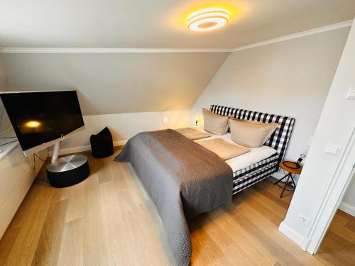 韦斯特兰Meer-Lust-Sylt Haus Mateika的一间卧室配有一张床和一台平面电视