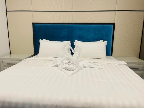 吉隆坡ASTRA @ Suite Platinum 2 KLCC的白色的床、白色床单和蓝色床头板