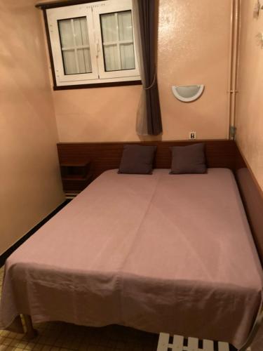 Ayzac-OstVilla At-Arcos的一个小房间的一个床位,设有窗户