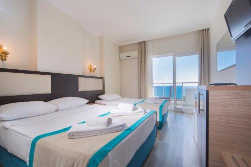 阿拉尼亚Club Sun Paradise Hotel的酒店客房设有两张床和电视。