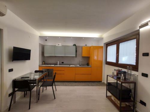 米兰G&G House的一间带桌子的厨房和一间带橙色橱柜的厨房