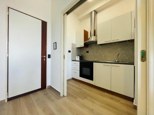 卡塔尼亚Le Dimore del Corso的厨房配有白色橱柜、水槽和门