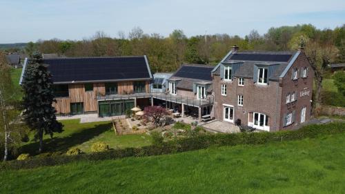 梅赫伦Hof van Kleeberg的享有大型房屋的空中景致,房屋上设有太阳能电池板