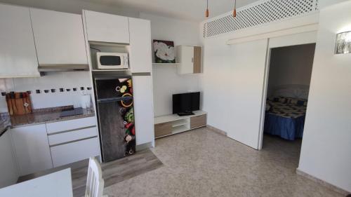 El AlquiánApartamento en Costacabana的白色的厨房配有冰箱和微波炉。