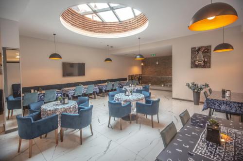 第比利斯Hotel Banovani的餐厅设有桌椅和大窗户。