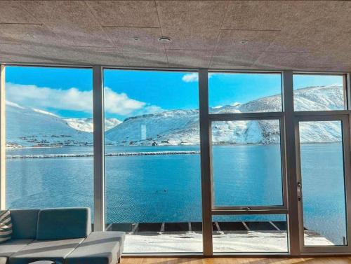 VestnanhavnPauli’s Boathouse的客房设有大窗户,享有白雪覆盖的山脉美景。