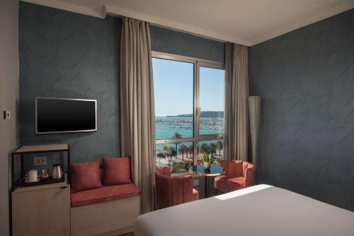斯培西亚NH拉斯伯泽亚酒店的酒店客房设有一张床,享有海景。