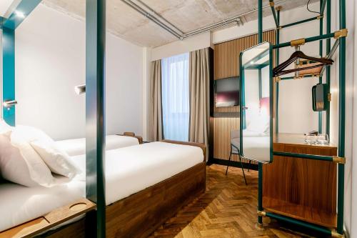 曼彻斯特YOTEL Manchester Deansgate的酒店客房,设有两张床和镜子