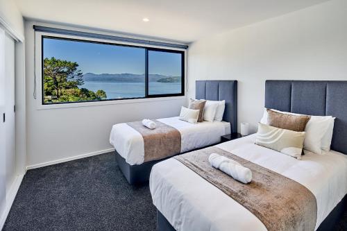 惠灵顿Brand New Townhouse with Ocean Views的带大窗户的客房内的两张床