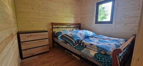 SpytkowiceChatka pod orzechem的小木屋内一间卧室配有一张床和一个梳妆台
