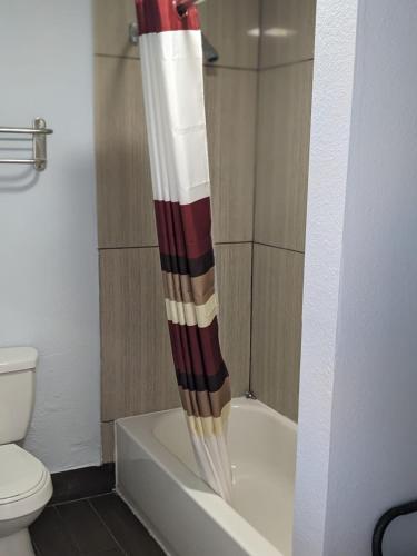 亚历山德里亚Budget Inn Alexandria的浴室位于卫生间旁,配有红色和白色的淋浴帘。