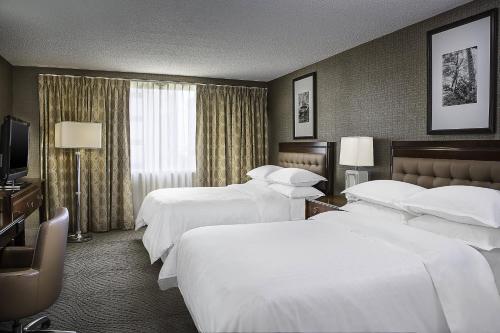 俄克拉何马城俄克拉荷马城喜来登中心酒店 的酒店客房设有三张床和电视。