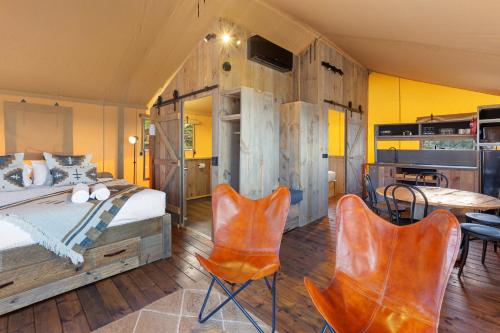 阿波罗湾比格弗阿波罗湾双鱼假日公园酒店的一间卧室配有一张床、两把椅子和一张桌子