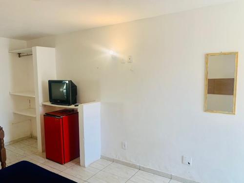 布希奥斯Suite familiar completa的客房设有小电视和红色冰箱。