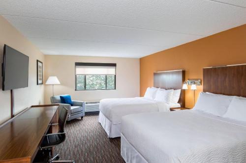 密尔沃基Four Points by Sheraton Milwaukee Airport的酒店客房设有两张床和电视。