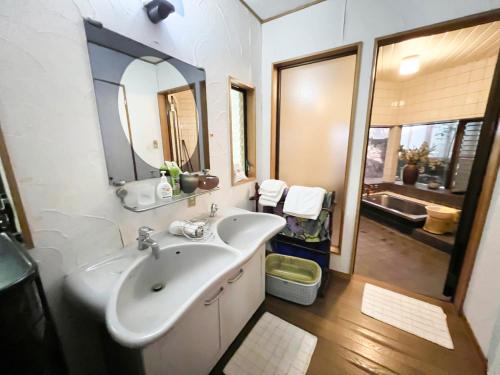 雾岛市貸別荘・グランピングひめしゃら的浴室配有盥洗盆、镜子和浴缸