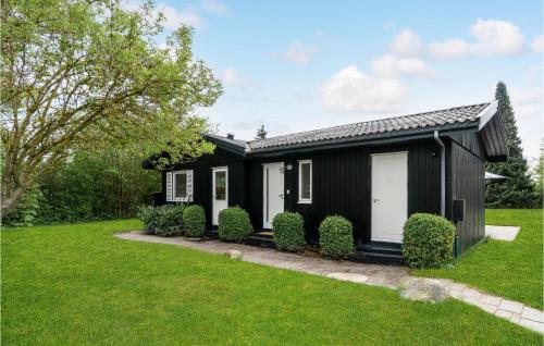 霍恩拜克2 Bedroom Pet Friendly Home In Hornbæk的一间黑色的房子,有白色的门和院子