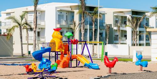 西迪拉哈尔CASA BAY BEACH OMK 2的建筑物前沙地的游乐场