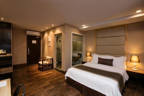 麦克坦Goldberry Suites and Hotel - Mactan的酒店客房设有一张大床和一间浴室。