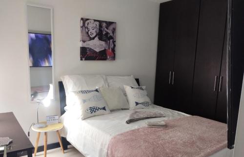 波哥大Apartamento sector exclusivo acogedor的一间卧室配有一张黑色橱柜的床