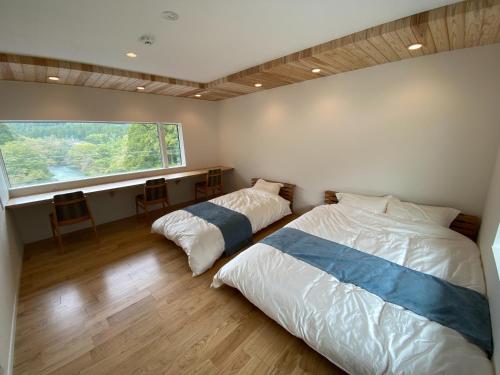 长滨市Ayu House - Vacation STAY 03971v的卧室设有两张床和大窗户
