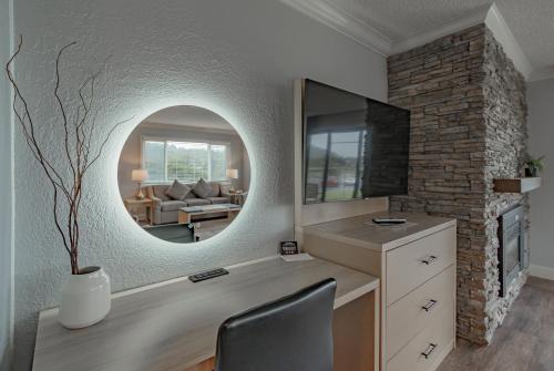 卡农海滩托尔瓦纳公寓式酒店的客房设有镜子、书桌和椅子