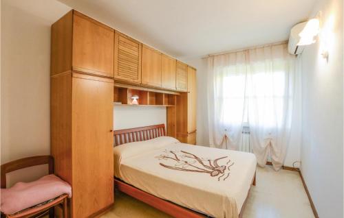 马里纳-迪-皮特拉桑塔3 Bedroom Lovely Home In Marina Di Pietrasanta的一间卧室配有一张床和一个木制橱柜
