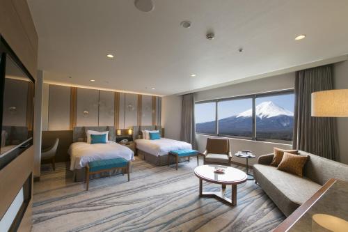富士吉田市海兰德水疗度假酒店的酒店客房,设有两张床和一张沙发