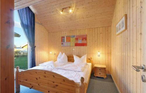 雷希林Gorgeous Home In Rechlin With Sauna的木制客房内的一间卧室,配有一张床
