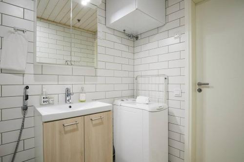 图尔库Fleminginkatu的白色的浴室设有水槽和一台洗衣机