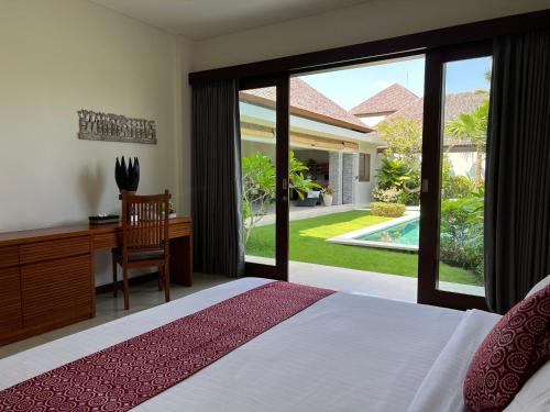 坎古Oshan Villas Bali的一间卧室配有一张床、一张书桌和一个窗户。
