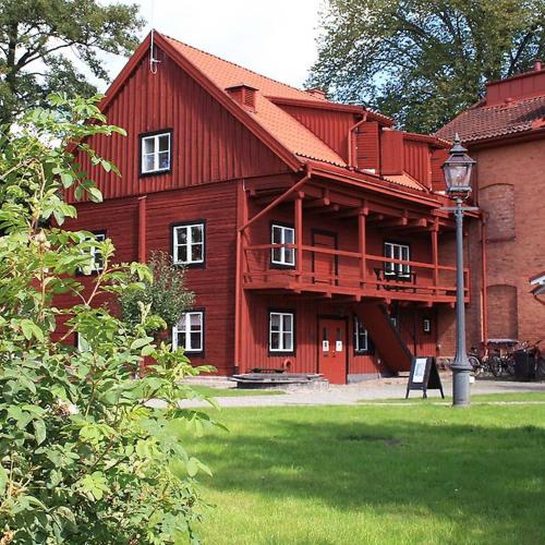 埃克舍Vandrarhemmet Garvaren gamla stan Eksjö的红屋顶和街灯的红色谷仓