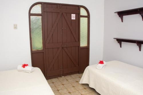 Santiago EsteCasa Carmen的一间设有两张床和木门的房间