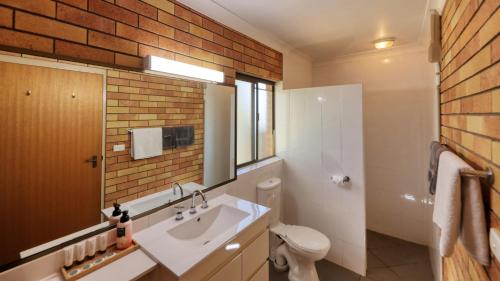 圣乔治Merino Motor Inn的一间带白色水槽和砖墙的浴室