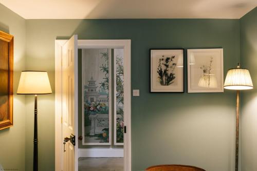 HawardenGardener's House - Hawarden Estate的一间拥有绿色墙壁的客房,墙上有三幅照片