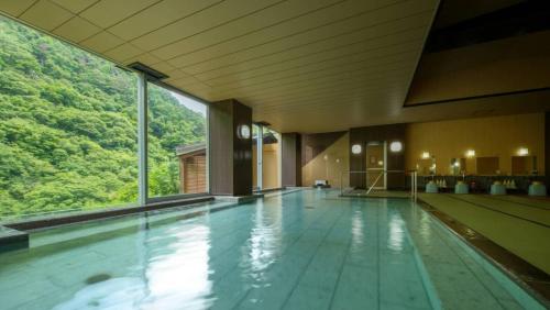 会津若松Ashinomaki Grand Hotel的大楼内带大窗户的大型游泳池