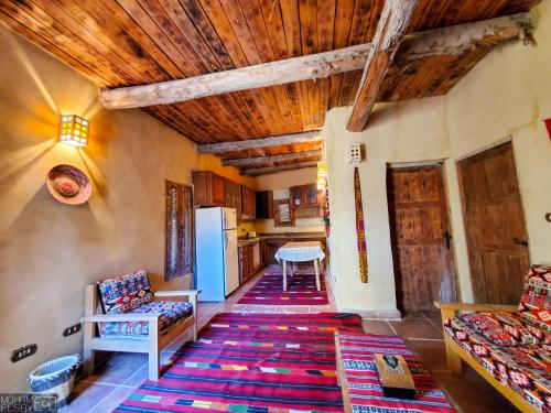 锡瓦Paloma Lodge的一间带木制天花板的客厅和一间厨房