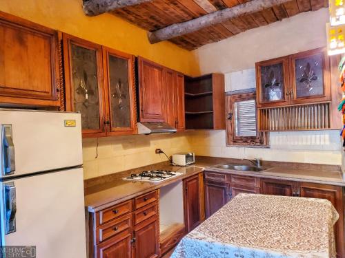 锡瓦Paloma Lodge的厨房配有木制橱柜和白色冰箱。