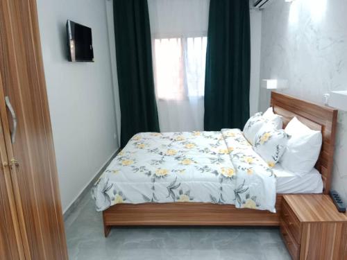 达喀尔Studio Emeraude - cosy et climatisé - Résidence Saraba Mermoz的卧室配有带白色棉被的床