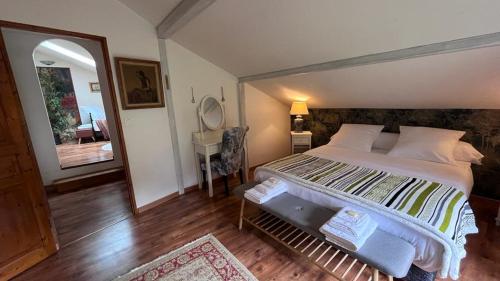 BrénodL'Ermitage de Meyriat的一间卧室配有一张大床和镜子
