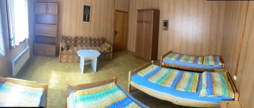 布赫洛维采Chata CONDI的一间卧室设有两张床、一张桌子和一个窗口