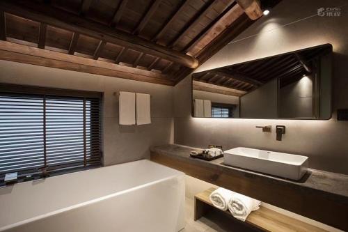 杭州杭州枫眠私享客栈的带浴缸、水槽和镜子的浴室