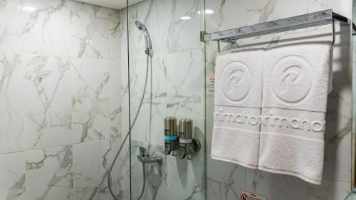 当格浪d'primahotel Airport Jakarta Terminal 3 Wellness Center的带淋浴的浴室,配有玻璃淋浴间门