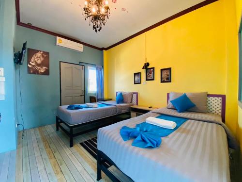 陶公Paksina Hotel的一间卧室配有两张带蓝色弓的床铺。
