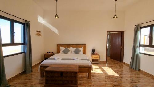 SalalahSAMA Jabal Samhan Hotel的一间卧室设有一张床和两个窗户。
