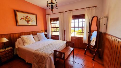 丰卡连特德拉帕尔马曼努埃拉度假屋的卧室配有床、镜子和窗户。