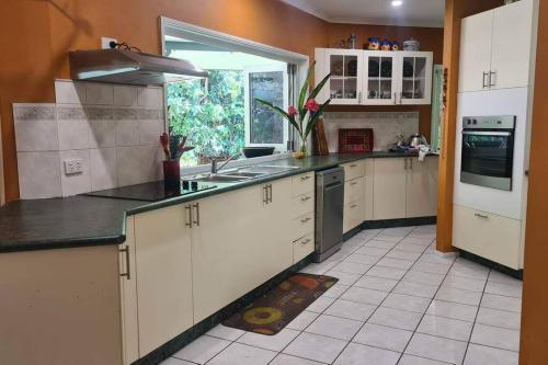 米申海滩Narragon的厨房配有白色橱柜、水槽和窗户。