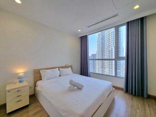 胡志明市123 Apartment in Vinhomes Central Park - Landmark 81的卧室设有白色的床和大窗户