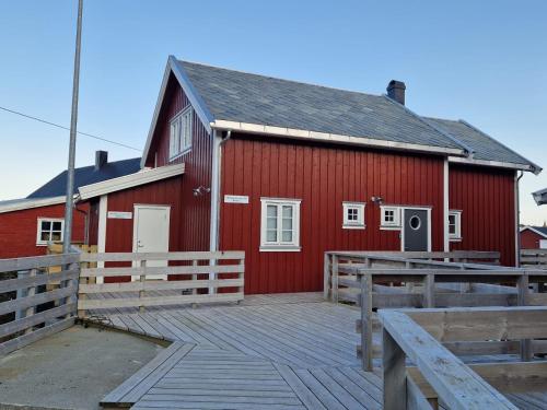 雷讷Andøy Vest Rorbuer Reine的前面的红色谷仓,有木甲板