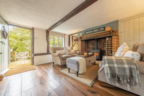 WenhastonWell Green Cottage的客厅设有壁炉和沙发。